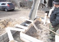Заливка раствора в траншею фундамента брусового дома